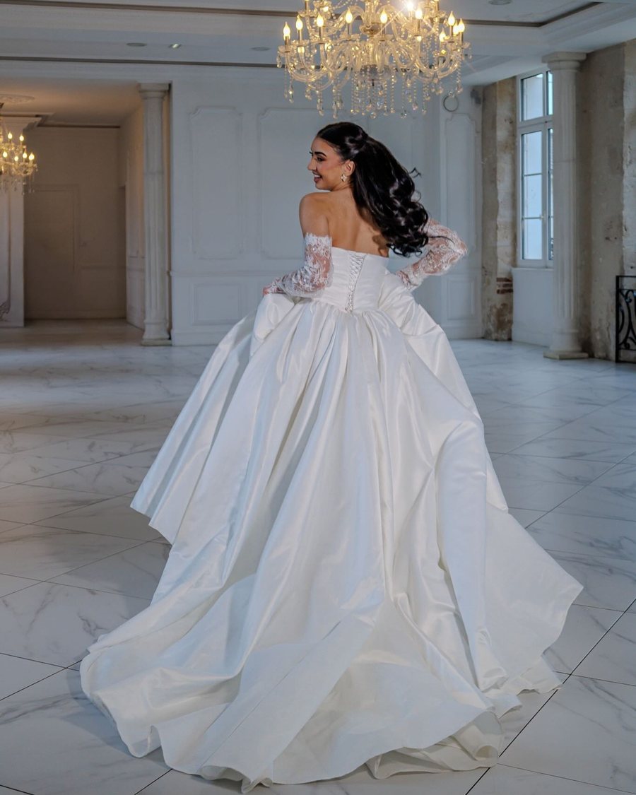 Robe de mariée princesse à traîne, jupe en taffetas, dans une salle de réception