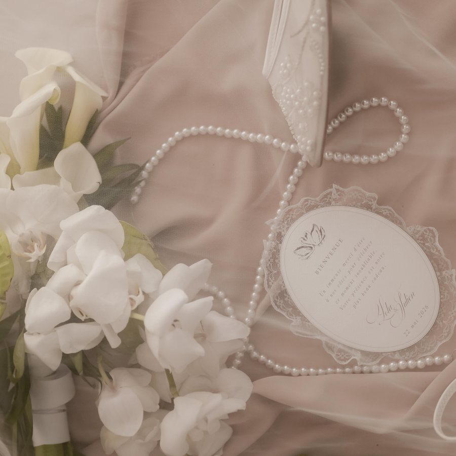 Accessoires de mariée et fleurs blanches disposés sur une étoffe